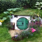 Casa de hobbit cu usa verde rotunda